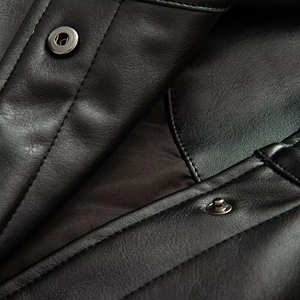 Detail of premium black faux leather jacket featuring silver metal snap buttons and fine stitching