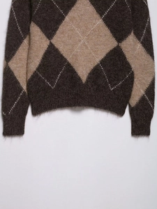 Detail of argyle knit sweater showing mohair texture and ribbed cuff in brown