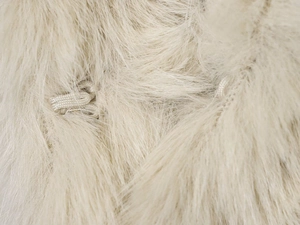 Macro de la texture en fausse fourrure crème avec détail de boucle de fermeture