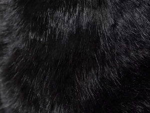 Macro detail of high-quality faux fur texture on a black hooded jacket for winter