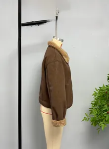 Detail view of brown faux suede jacket featuring soft cream shearling lining and collar