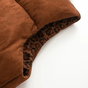 Detailed close-up of brown faux suede puffer vest with leopard print lining and thick padding