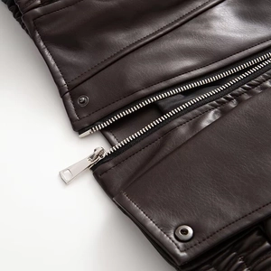 Women's dark brown oversized faux leather jacket with metal zippers and button details