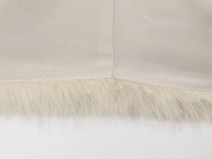 Gros plan sur le satin doré champagne avec bordure en fausse fourrure crème douce