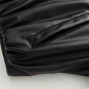 Detail shot of black faux leather flight jacket showing the welt pocket and textured fabric