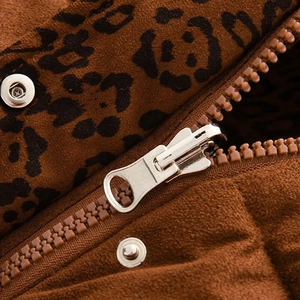 Detail of leopard print puffer vest featuring silver metal zippers and snap buttons