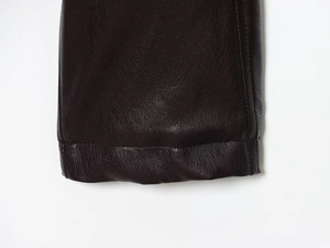 Detail view of premium dark brown faux leather texture and precision stitching on jacket