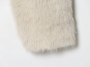 Gros plan sur la texture en fausse fourrure crème douce et épaisse pour manteau d'hiver
