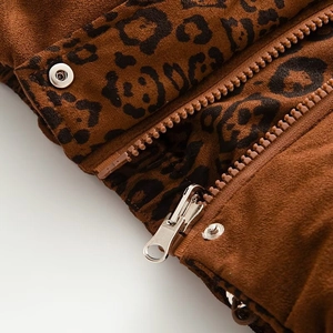 Macro view of leopard print faux suede fabric with metal zipper and snap button detail