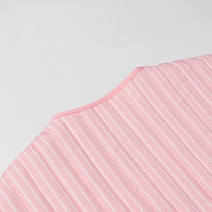 Macro view of pink and white striped cotton coat showing fine stitching and piping detail