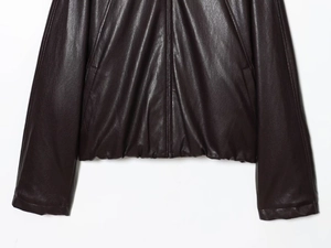 Detail of faux leather bomber jacket showing zipper closure and elastic ribbed hemline