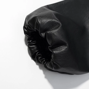 Detailed macro view of the elastic pleated cuff and shiny black leather texture on jacket