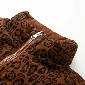 Detail of leopard print puffer vest featuring a stand collar and metal zipper closure