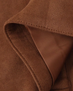 Makroaufnahme der braunen Wildlederjacke mit Stofftextur, Nähten und Seidenfutter