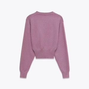 Détail du pull en tricot lilas à manches longues avec col rond et finitions en maille côtelée