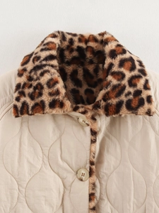 Detail of leopard print faux fur collar and wave quilted texture on beige winter coat