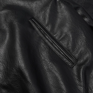 Detail shot of black faux leather texture and premium stitching on slanted welt pocket