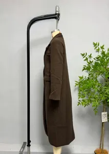 Detail view of a long dark brown wool coat featuring a lapel collar and side pockets