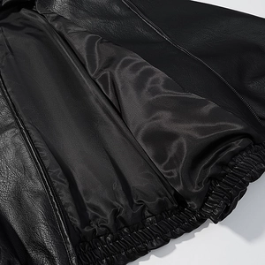 Detail view of the black leather jacket featuring inner satin lining and elastic waistband