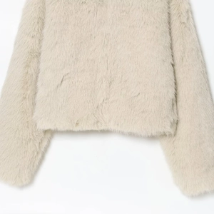 Manteau court en fausse fourrure beige clair avec texture pelucheuse et poils longs