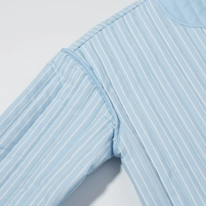 Detailed macro view of blue and white striped quilted fabric and stitching quality