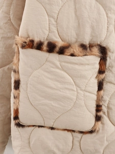 Close-up of beige quilted jacket featuring patch pocket with leopard faux fur trim detail