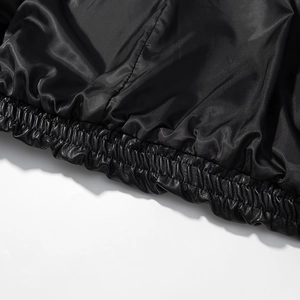Detailed macro view of black faux leather jacket hem with elastic windproof ribbed texture