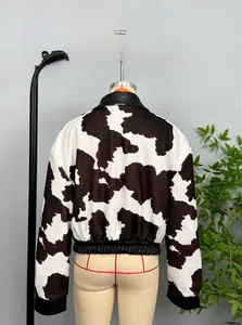 Detail of cropped jacket featuring faux cow print and black leather collar on back view