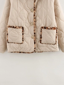 Detail of beige quilted jacket featuring leopard print faux fur trim and front buttons