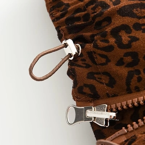 Macro shot of leopard print puffer vest featuring silver zipper and elastic drawstring