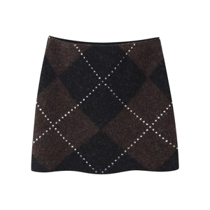 Detailed close-up of argyle pattern knit mini skirt in brown and black textured fabric