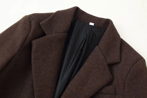 Detailed view of dark brown wool coat with classic lapel collar and black silk lining