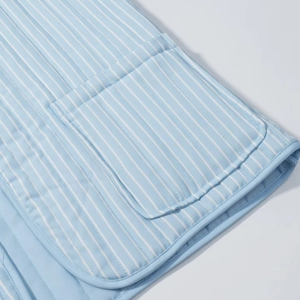 Close-up of quilted vertical striped cotton jacket showing pocket and fine stitching