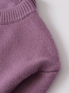 Vue détaillée d'un pull en maille violette montrant la texture fine et le col côtelé