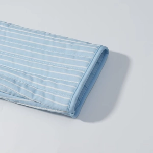 Close-up detail of blue striped quilted fabric with high-quality stitching and piping