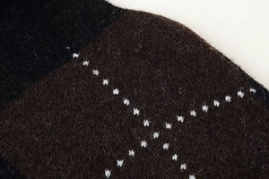 Close-up of diamond argyle knit texture with soft wool fibers in black and brown