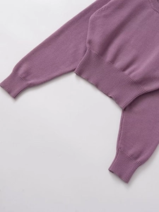 Vue détaillée du pull en tricot violet montrant les poignets côtelés et la texture douce