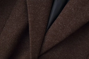 Macro shot of dark brown wool blend coat fabric showing texture and smooth black lining