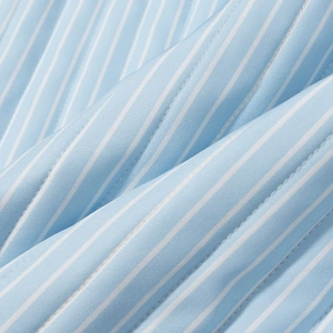 Detailed view of sky blue striped cotton fabric with white decorative quilted stitching