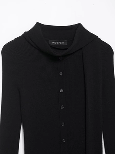 Détail d'un cardigan noir en maille côtelée avec boutons frontaux et col écharpe unique