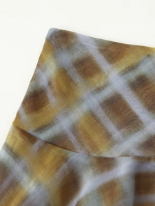 Vue détaillée de la texture du tissu écossais tie-dye aux tons jaune et marron