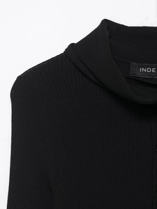Détail macro du pull en maille côtelée noire avec col montant et étiquette tissée interne