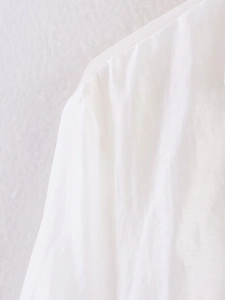 Macro detail of lightweight semi-transparent white shirt fabric and shoulder seam