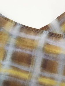 Gros plan détaillé sur la texture du tissu à carreaux jaune et gris et les coutures soignées