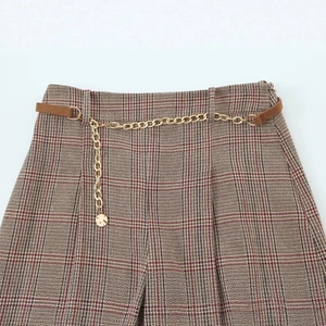 High-waisted houndstooth shorts with gold chain detail and brown leather belt loops
