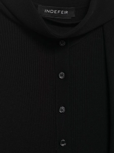 Gros plan sur la texture en maille côtelée et les boutons noirs du cardigan