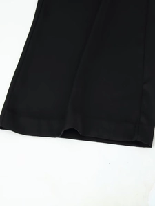 Detail view of smooth black satin trousers hem with high-quality invisible stitching