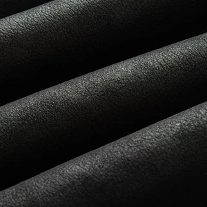 Macro close-up showing the soft lychee texture and matte finish of the black leather jacket