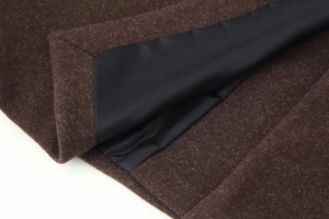 Close-up of brown wool coat showing high-quality fiber texture and black inner lining