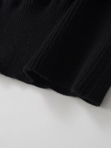 Gros plan sur la maille côtelée noire d'un pull à manches longues et sa texture